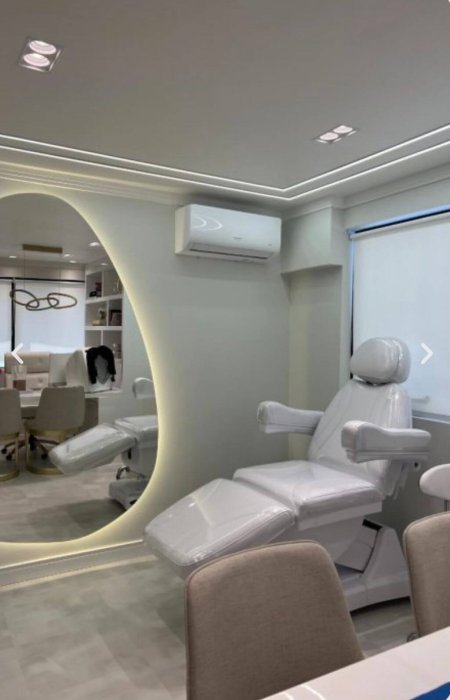 Sala de procedimentos do consultório, com poltrona reclinável e espelho oval retroiluminado