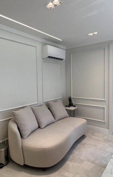 Sala de espera do consultório com sofá estofado e ar-condicionado